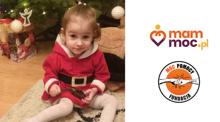 Mała dziewczynka w stroju Świętego Mikołaja siedzącej na podłodze obok choinki.