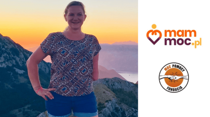 Kobieta stojąca na szczycie góry o zachodzie słońca.