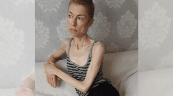 Kobieta siedząca na kanapie ze skrzyżowanymi nogami.