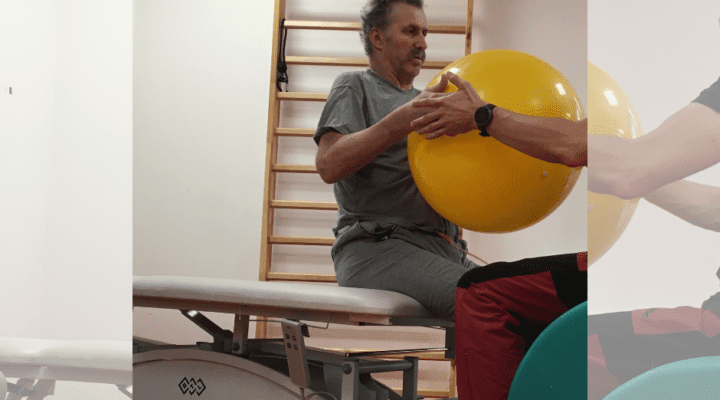 Zdjęcie dwóch mężczyzn wykonujących fizykoterapię z piłką.