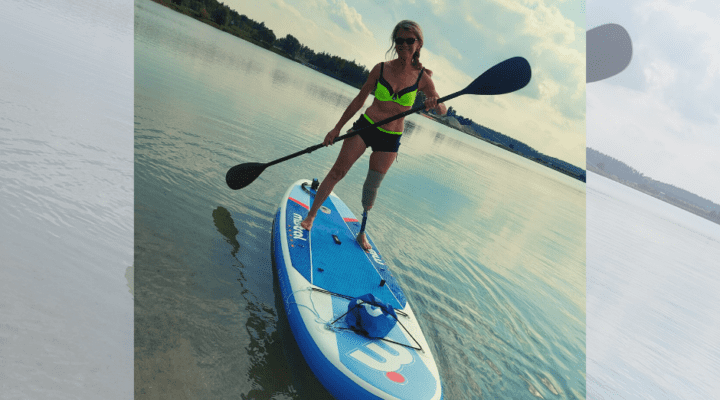 Kobieta na desce wiosłowej w wodzie.