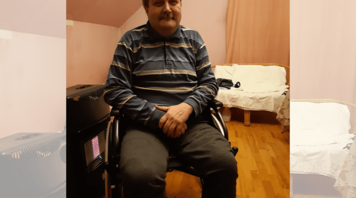 Mężczyzna na wózku inwalidzkim siedzącym w pokoju.