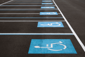 Zdjęcie parkingu z namalowanymi na nim symbolami handicapowymi.