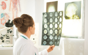 Kobieta w płaszczu laboratoryjnym patrzy na promień X -.