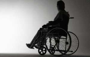 Sylwetka mężczyzny na wózku inwalidzkim.