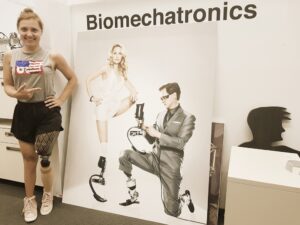 Kobieta stojąca przed znakiem, który mówi biomechatronika.