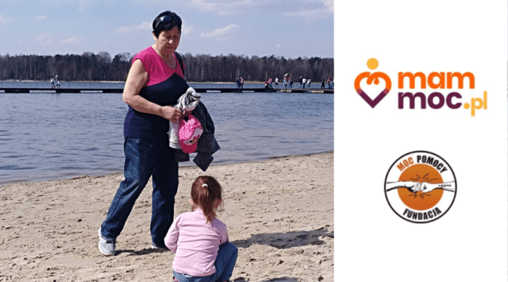 Kobieta i dziecko na plaży ze znakiem z napisem mama Moc.