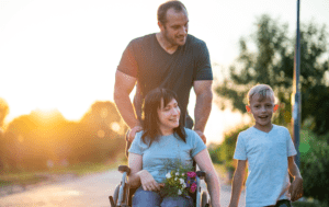 Mężczyzna na wózku inwalidzkim z dwójką dzieci.