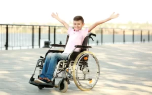 Zdjęcie młodego chłopca na wózku inwalidzkim.